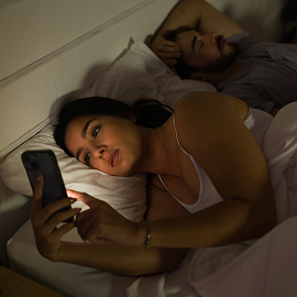 Woman on her phone in bed